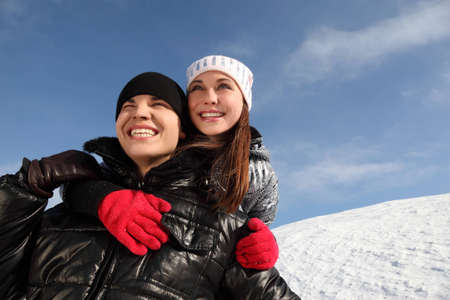 young girl embracing man from back, smiling and looking left, winter dayの写真素材