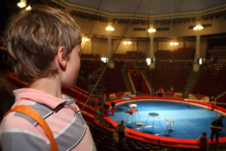 little boy in circus with blue arena waiting for performance and looking at arenaのeditorial素材