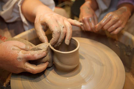 Hands of master creating pot on potter's wheel. Traditional craft. Focus on the hands.のeditorial素材