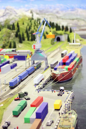 model of railroad station and sea port. ship, railroad, train, buildings and other constructions. focus on a cargo in center of imageの写真素材