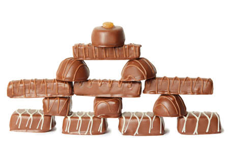 many chocolate appetizing candys with icing pyramid figure, full view, isolated