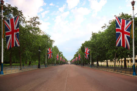 Alley Mall, Buckingham Palace are seen in the distance. Right and left of the mall hang British...