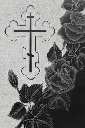 black granite gravestone with engraving picture, roses ornament and christian crossの写真素材