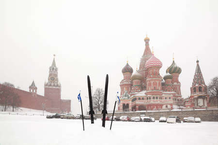 Cross-country skis and poles stuck in snow on Red Square near St. Basil Temple and Spasskaya Tower...