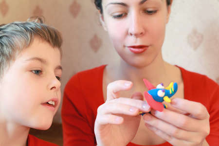 Mother and  son play with  home-made elephant from plasticine
