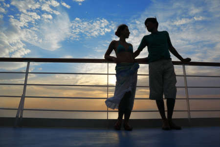 man and woman on deck of cruise ship. man looking at woman and woman looking at man.