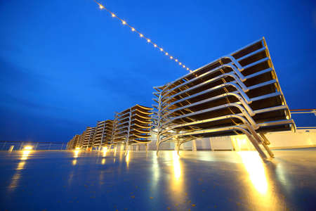 Set of illuminated deck-chair stack on ship deck in the evening