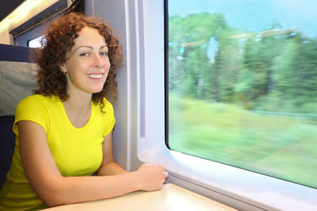 Woman rides in  speed train near window