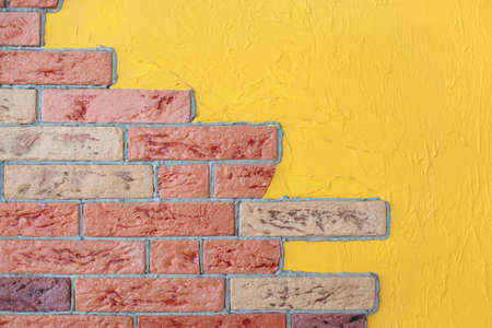 closeup of red brick wall and yellow plaster wall, bright interior