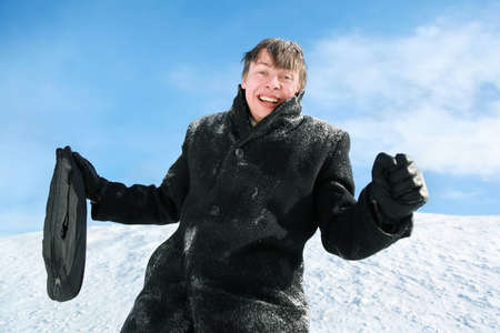 Man with brief-case stands by winter day on snow and rejoices
