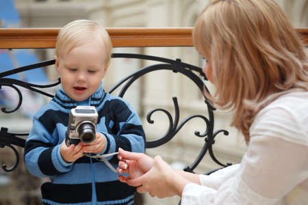 Child and mother. Boy examines photo with digital camera.のeditorial素材