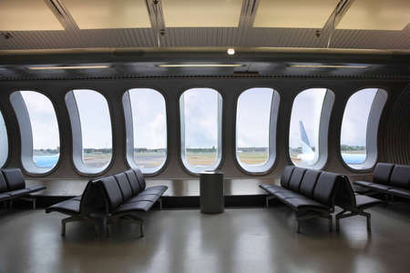 Waiting room at the airport. Several planes are seen outside windows