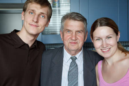 Family of three people. Man, old man and girl smiling looking at camera.