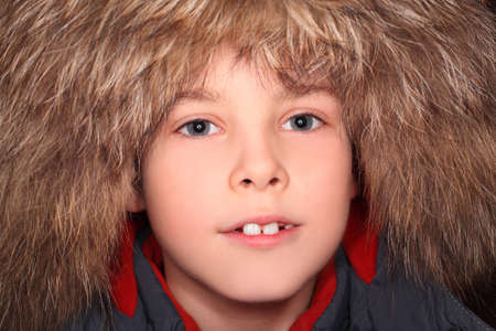 portrait of little boy in big fur hood, looking at camera