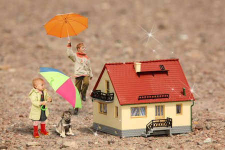 children with umbrellas, puppy and House model on ground collageの写真素材