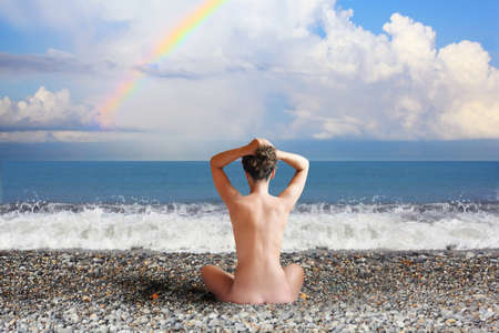sitting woman and rainbow on sea coast collageの写真素材