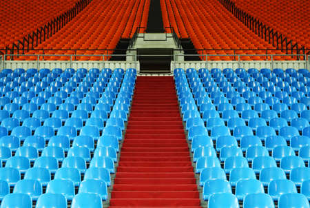 many rows of red and blue empty plastic seats at stadium; stairwayのeditorial素材