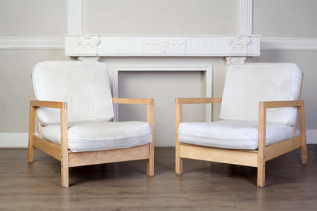two white chairs and beautiful ornate decorative plaster moldings on wall