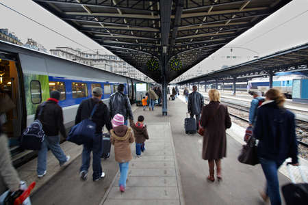Passengers from the arrived train go by the platform.
