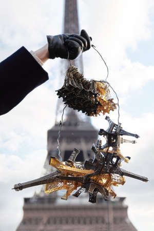 hand in a black leather glove holding bunch of souvenirs, Eiffel Towerの写真素材