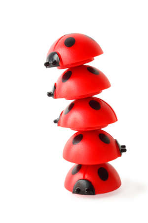 inclined tower made of five red small ladybugs isolated on whiteの写真素材