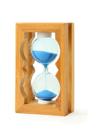 pure blue sand falls into wooden hourglass isolated on white