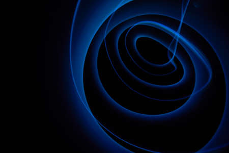 Abstract colorful spiral on black background, bright blue freezelight paint 