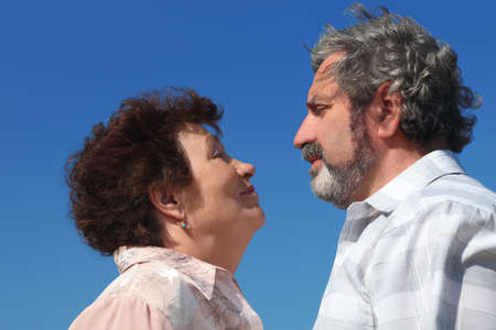 old woman and man looking to each other, blue sky