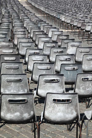 Many rows of gray, plastic chairs outdoorの写真素材