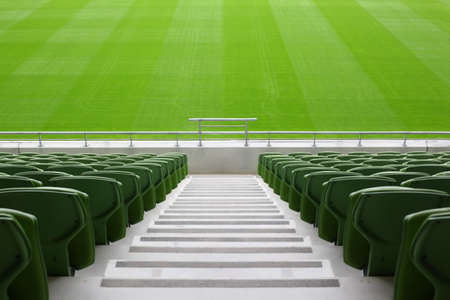 Rows of folded, green, plastic seats in very big, empty stadiumの写真素材