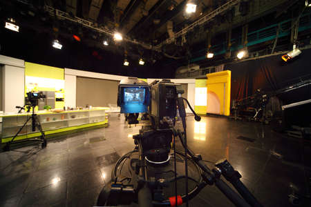 professional black video camera in television studio, light scene