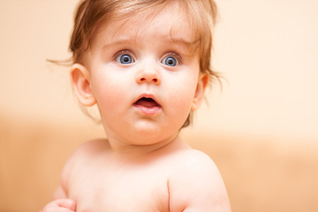 little baby looking away with his mouth openの写真素材