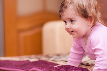 little baby lying on the blanket and showing tongueの写真素材