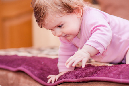 little baby lying on the blanket and showing tongueの写真素材