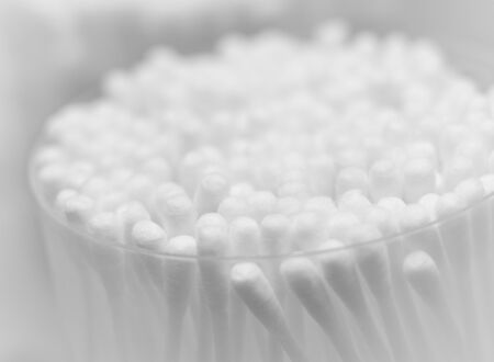 white cotton swabs are in transparent glass. black and white