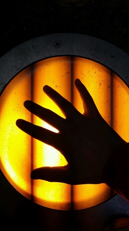 hand silhouette against an orange light