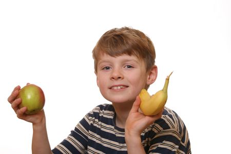 Happy and healthy boy shows an apple and a bananaの写真素材