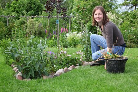 Happy woman works in the gardenの写真素材