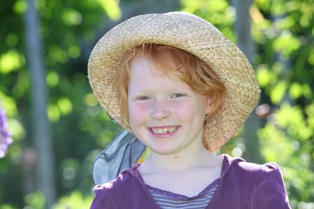 Happy young girl with straw hatの写真素材