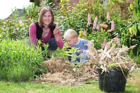 Happy woman and son work in the gardenの写真素材