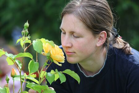 Attractive smiling young lady enjoys her gardenの写真素材