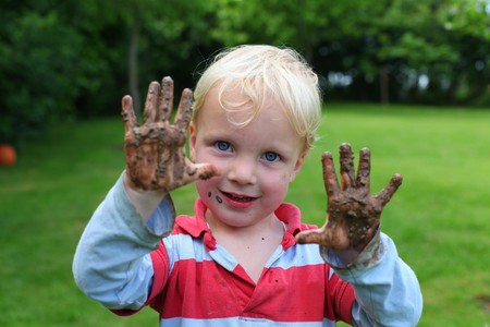Young boy shows his muddy handsの写真素材