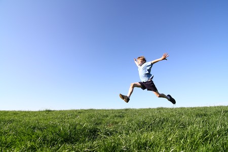 A sportive young boy makes a big jumpの写真素材