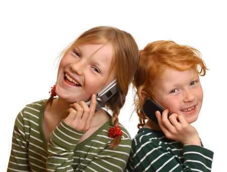 Two young girl with cell phones calling each otherの写真素材