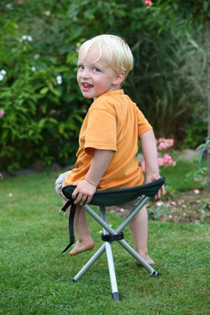 Young boy sitting on a folding camping chairの写真素材