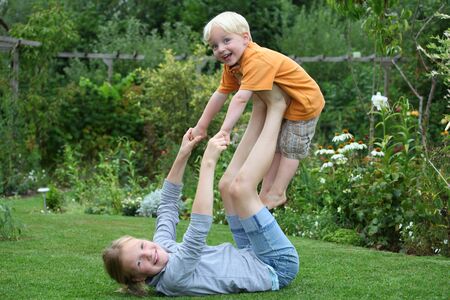 Laughing boy and girl playing in the gardenの写真素材