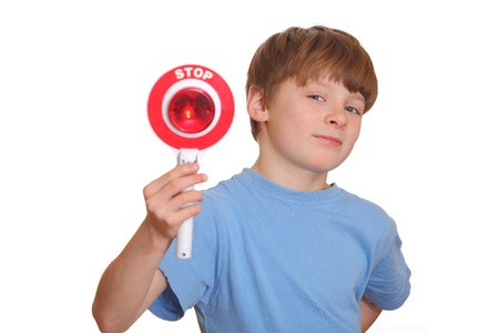 Humorous young boy shows stop sign isolated on white backgroundの写真素材