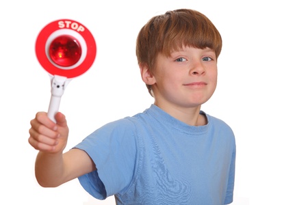 Confident young boy shows stop sign isolated on white backgroundの写真素材