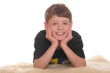 Portrait of a smiling young boy lying on the floorの写真素材