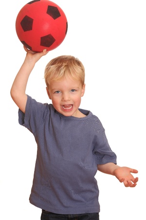 Portrait of a young boy throwing a red ballの写真素材